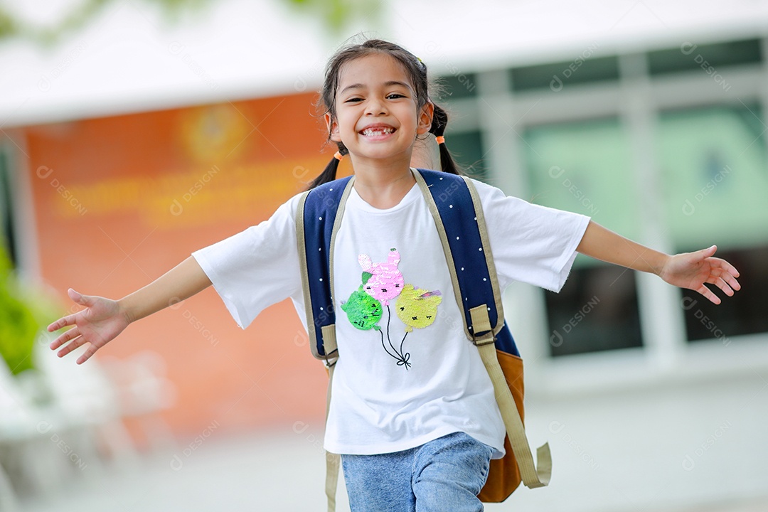 Criança menina asiática com uma mochila indo para a escola com diversão.