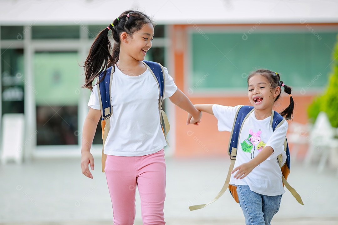 Criança menina asiática com uma mochila indo para a escola com diversão.