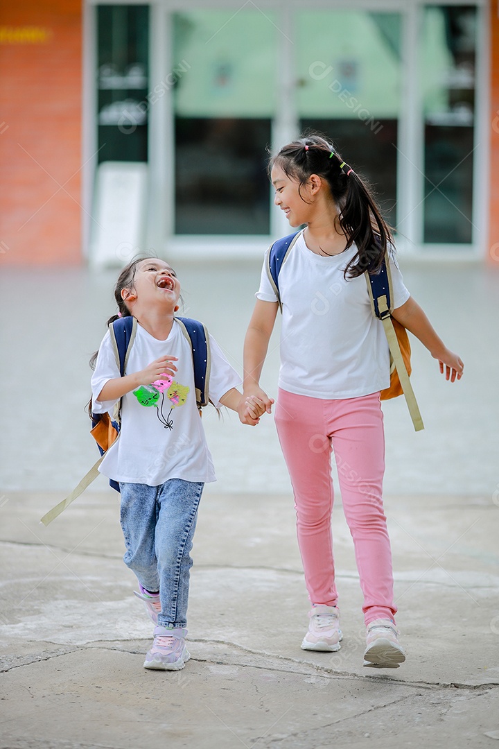 Criança menina asiática com uma mochila indo para a escola com diversão.