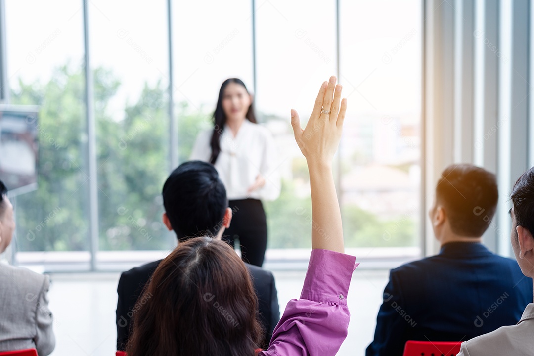 Pessoa de negócios levantando a mão durante o seminário.