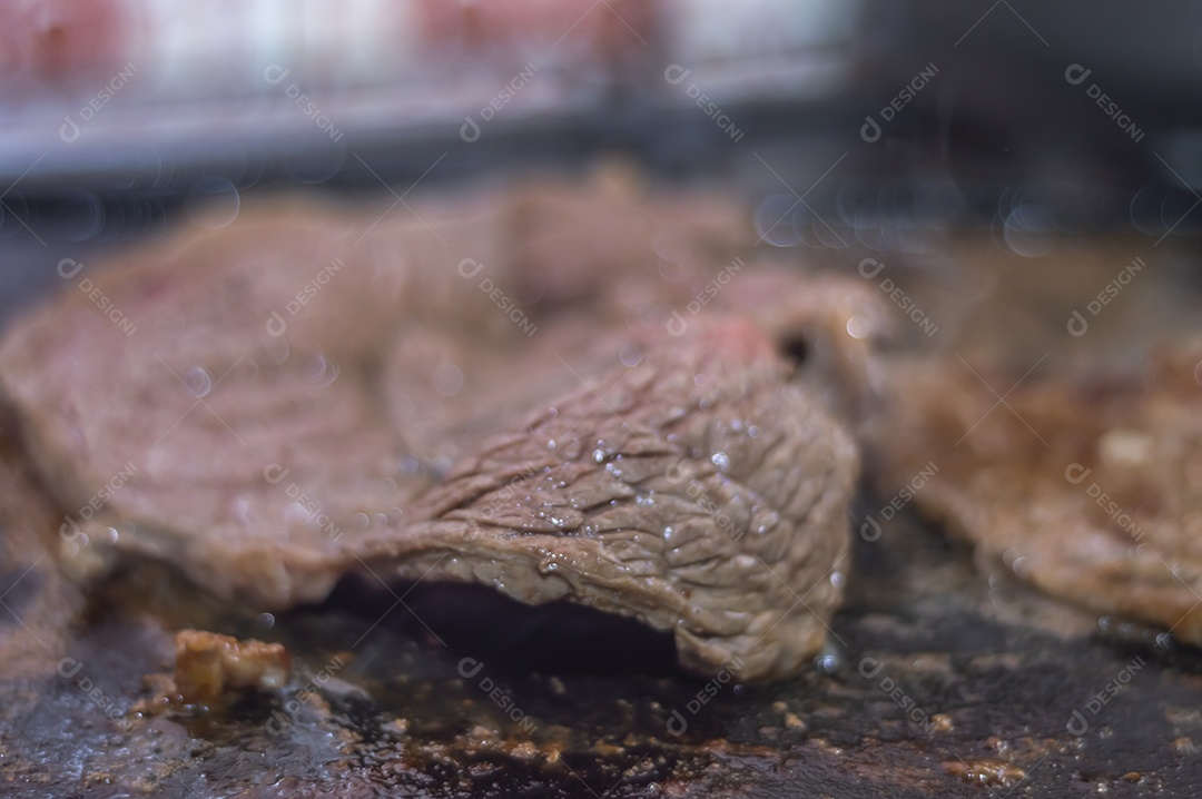 Conceito de churrasco em casa, carne sendo preparada em uma placa de fogão caseira