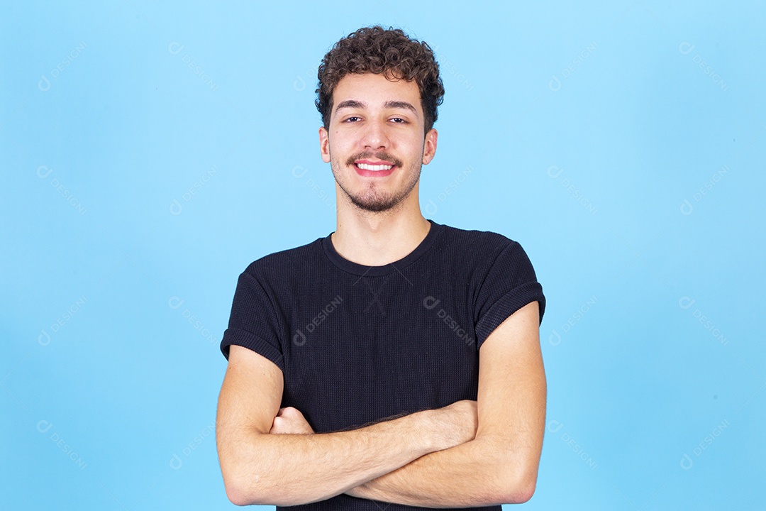 Homem jovem sorridente de braços cruzados