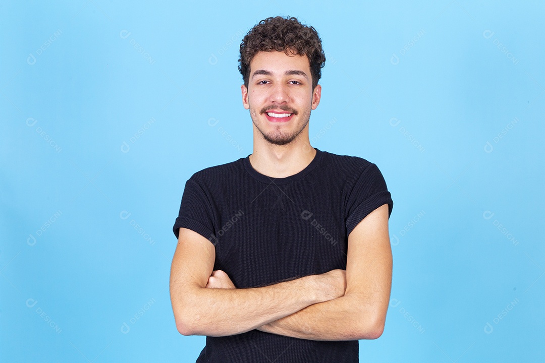 Homem jovem sorridente de braços cruzados