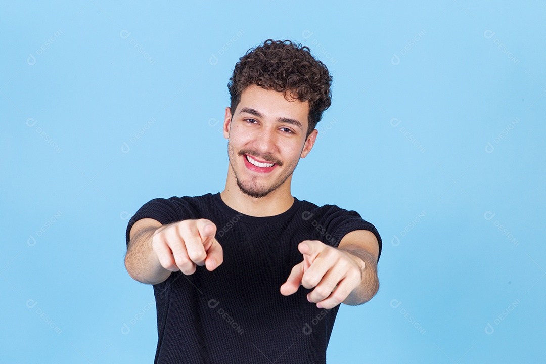 Homem jovem sorridente apontando dedo para frente