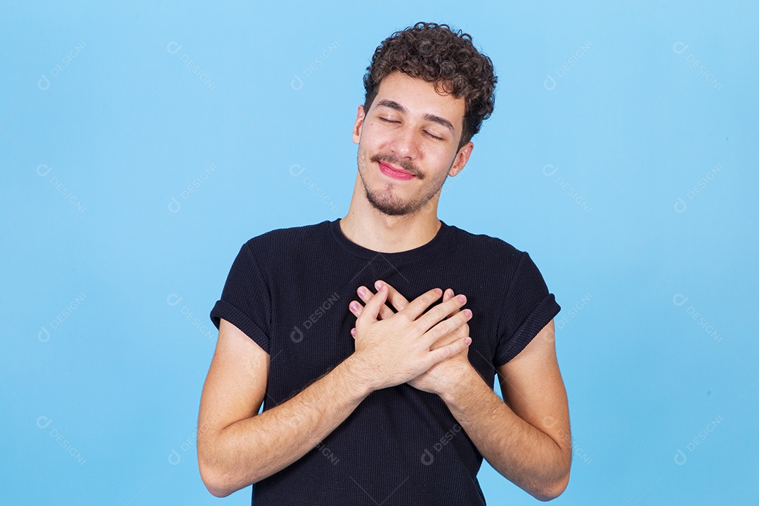 Homem jovem sorridente com as mãos no peito
