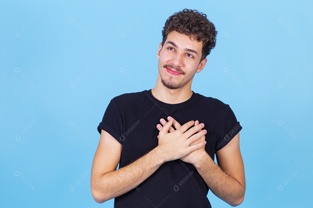 Homem jovem sorridente com as mãos no peito