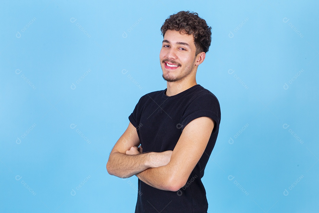 Homem jovem sorridente com braços cruzados