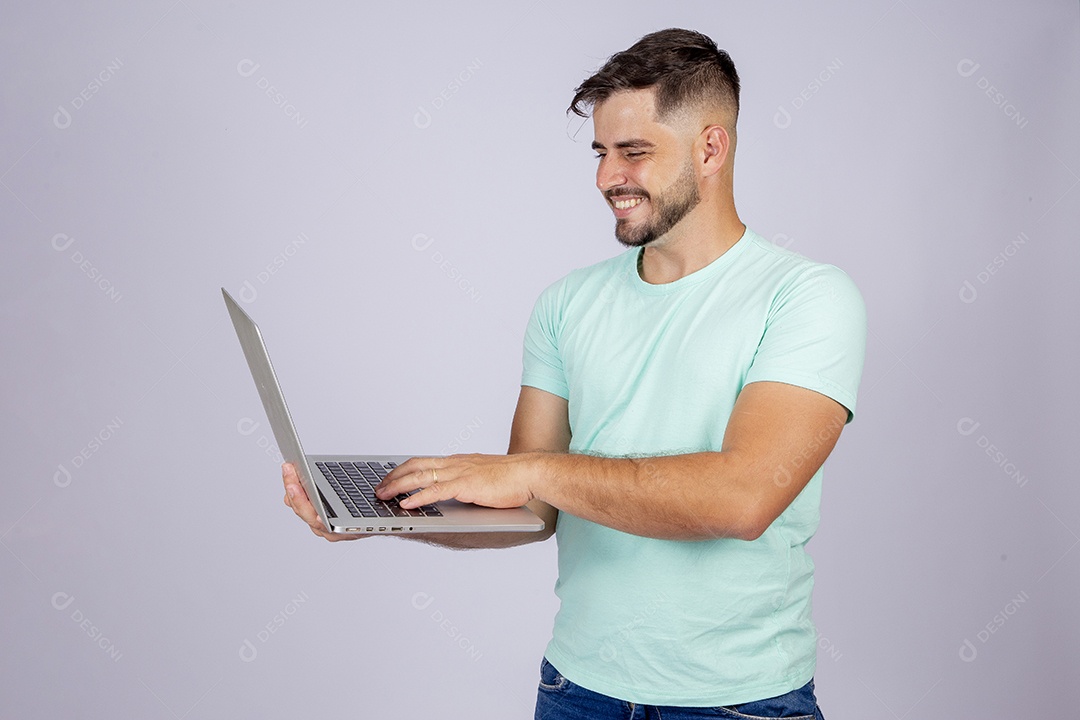 Homem jovem barbudo mexendo notebook sobre fundo isolado
