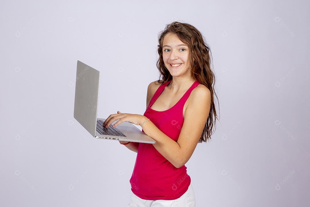 Linda menina jovem mexendo notebook sobre fundo isolado
