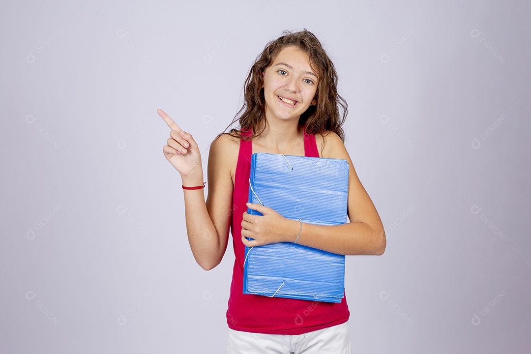 Linda menina jovem segurando material escolar sobre fundo isolado