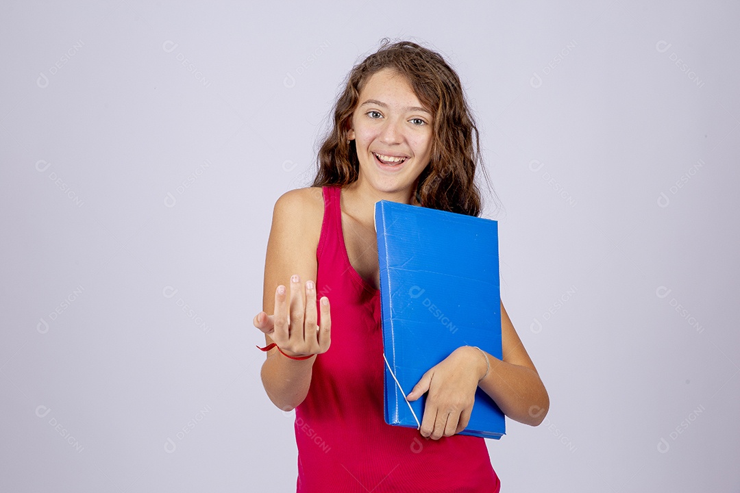 Linda menina jovem segurando material escolar sobre fundo isolado