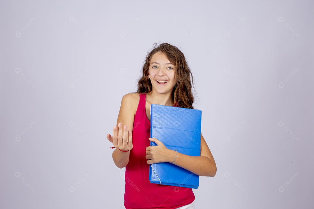 Linda menina jovem segurando material escolar sobre fundo isolado