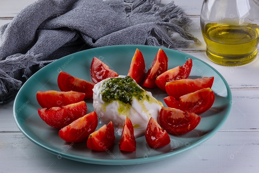 Mussarela de búfala burrata coberta com molho pesto e rodelas de tomate.
