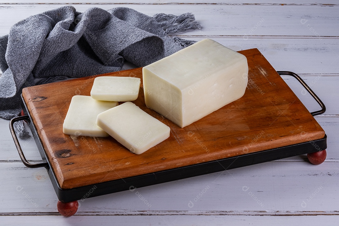 Barra de mussarela de búfala fatiada na placa de madeira.