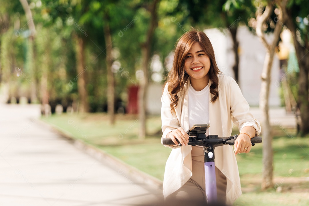 Mulher asiática andando de scooter elétrica no parque, conceito de estilo de vida