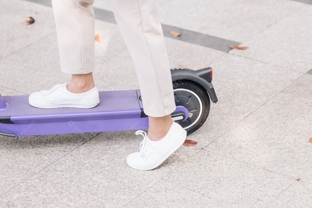 Mulher asiática andando de scooter elétrica no parque, conceito de estilo de vida