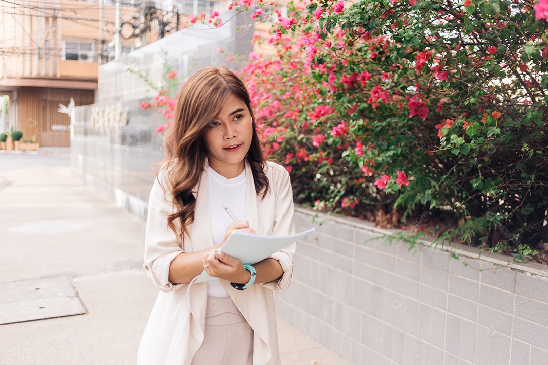 Jovem empresária asiática escrevendo no caderno