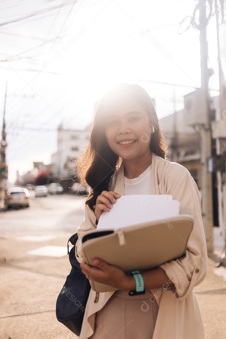 Retrato de uma jovem asiática sorridente segurando a prancheta e olhando para a câmera
