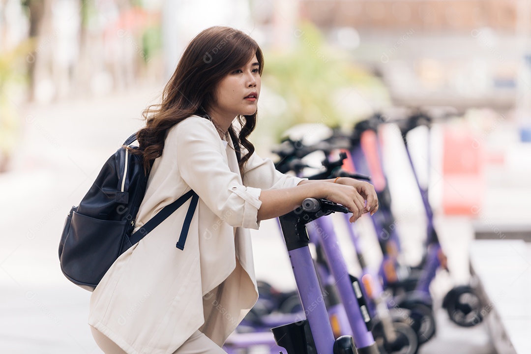 Retrato de jovem asiática andando de scooter elétrica no parque
