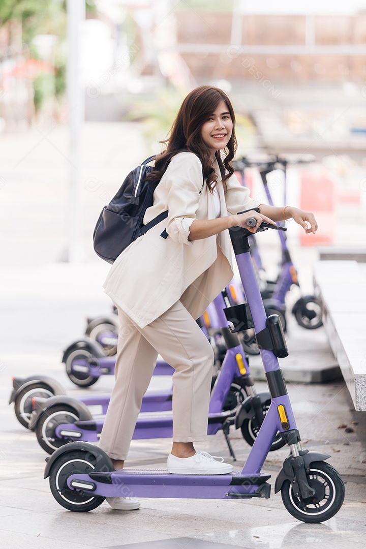 Retrato de jovem asiática andando de scooter elétrica no parque