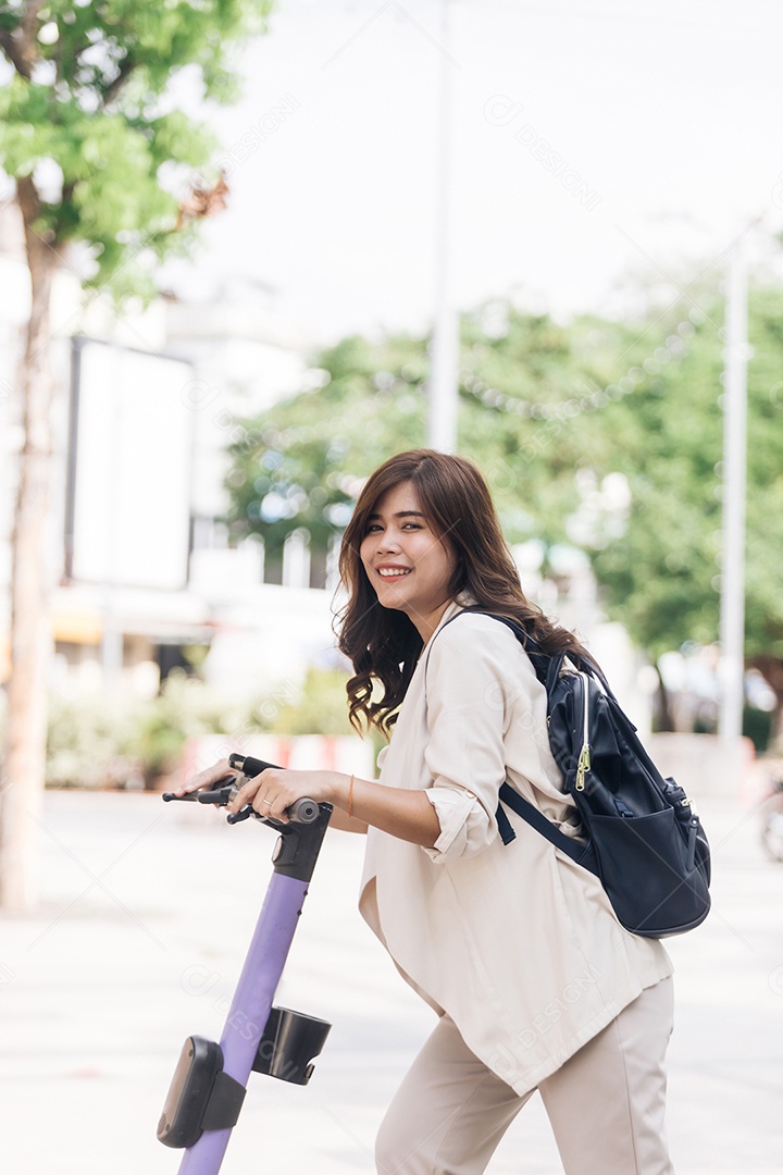 Retrato de jovem asiática andando de scooter elétrica no parque