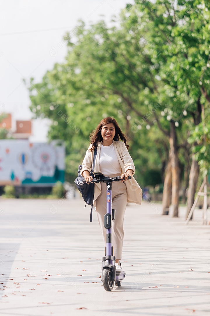 Retrato de jovem asiática andando de scooter elétrica no parque