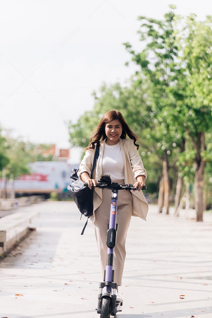 Retrato de jovem asiática andando de scooter elétrica no parque