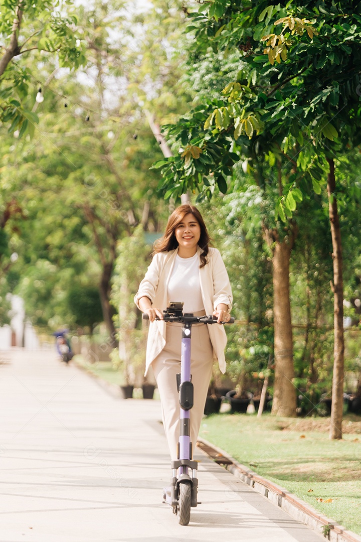 Mulher asiática andando de scooter elétrica no parque, conceito de estilo de vida