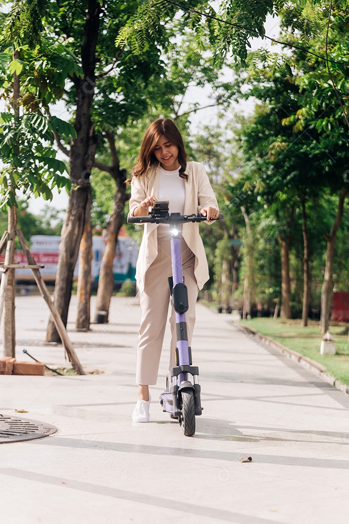 Mulher asiática andando de scooter elétrica no parque, conceito de estilo de vida