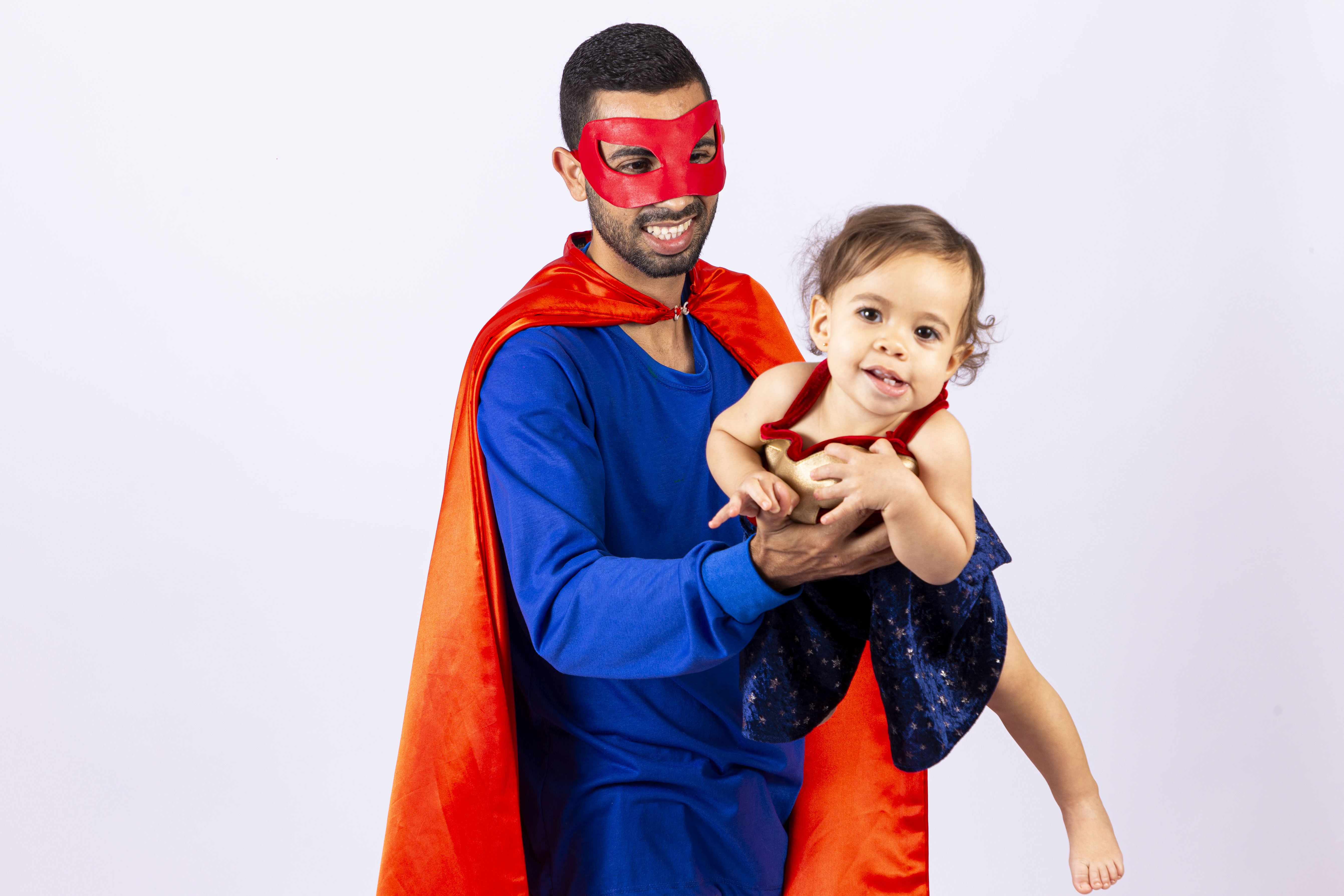 Pai e filha fantasiados de super heróis em fundo isolado