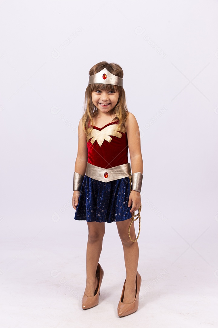 Garotinha linda com fantasia da mulher maravilha em fundo isolado