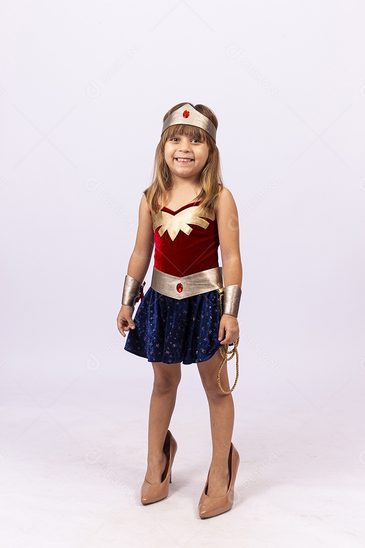 Garotinha linda com fantasia da mulher maravilha em fundo isolado