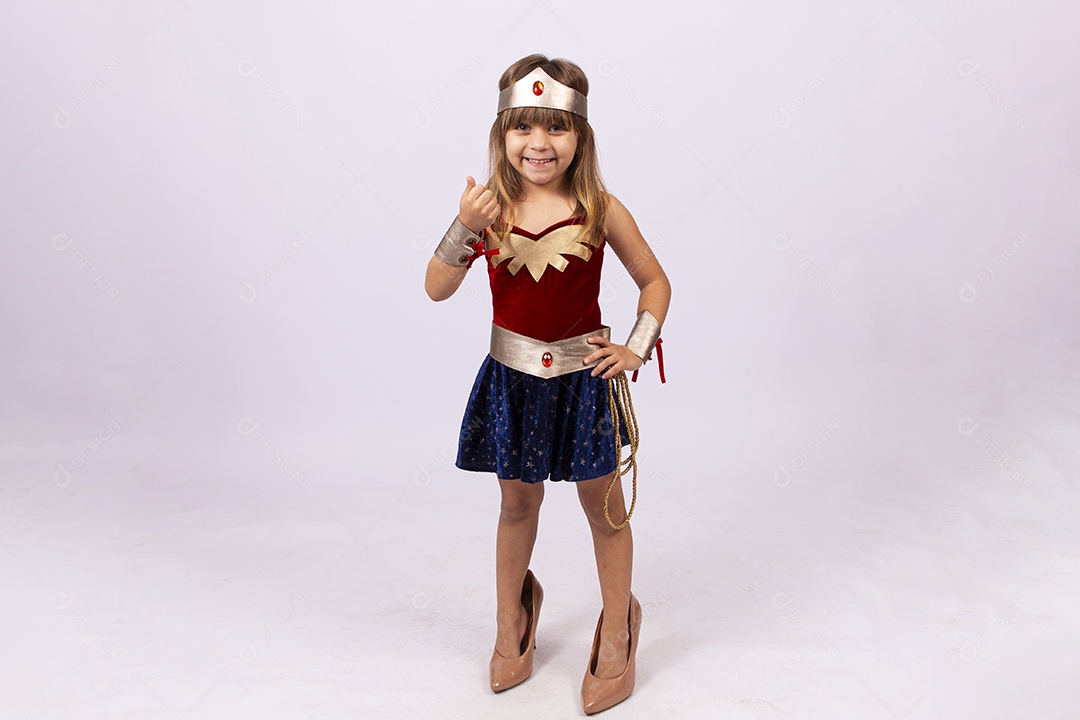 Garotinha linda com fantasia da mulher maravilha em fundo isolado