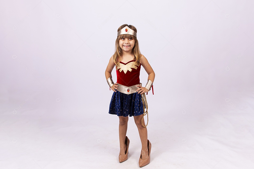 Garotinha linda com fantasia da mulher maravilha em fundo isolado