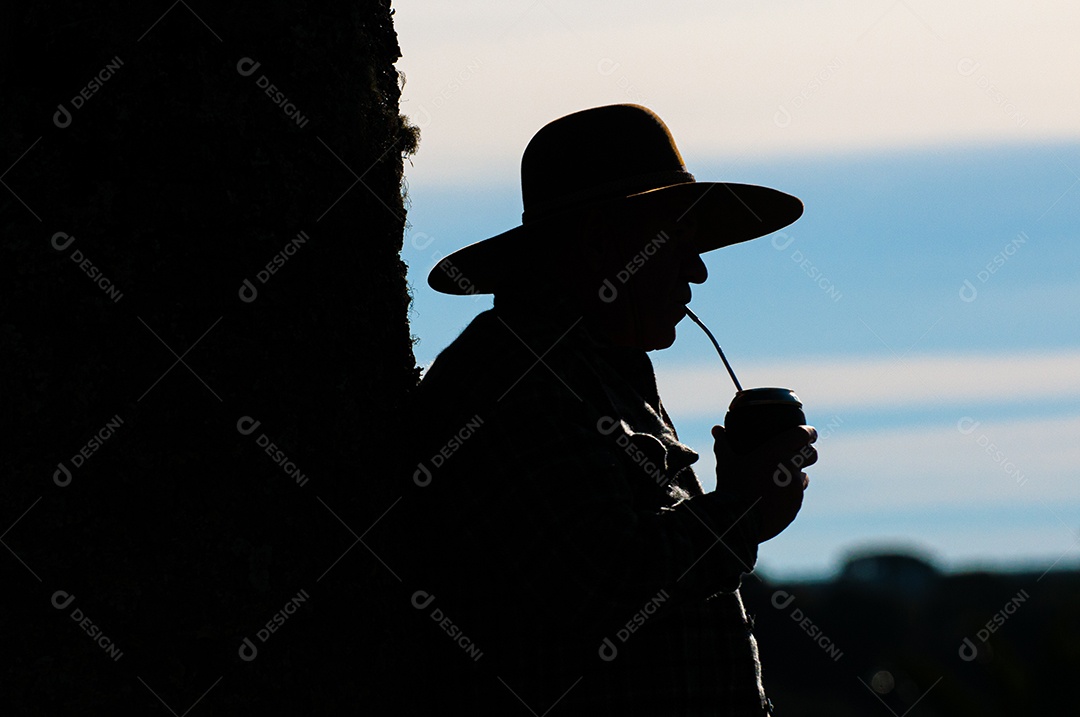 Homem na fazenda tomando chimarrão