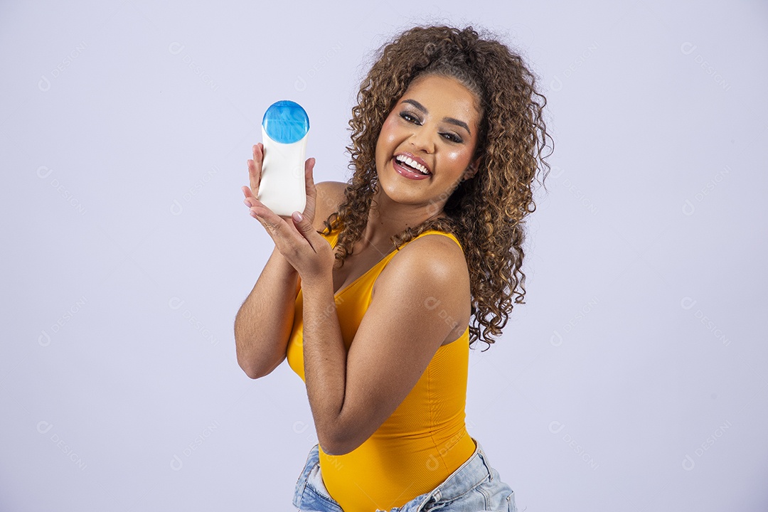 Linda mulher de maiô amarelo segurando frasco de protetor solar em fundo branco