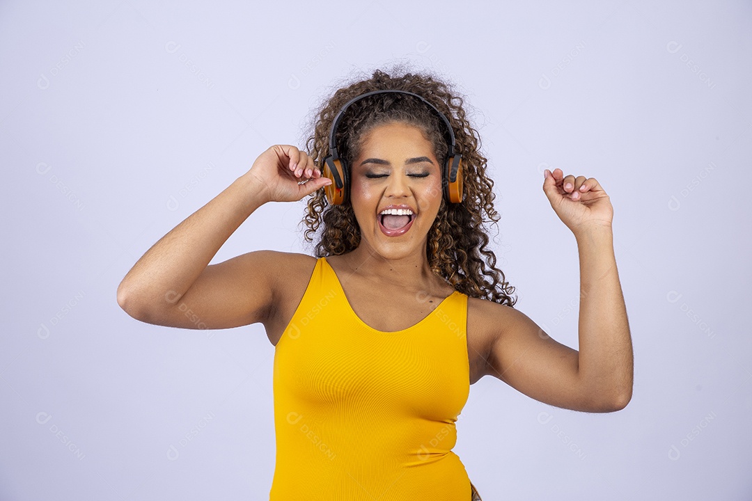 Linda mulher com maiô amarelo com fone de ouvido em fundo branco