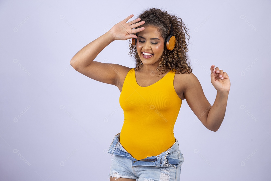 Linda mulher com maiô amarelo com fone de ouvido em fundo branco