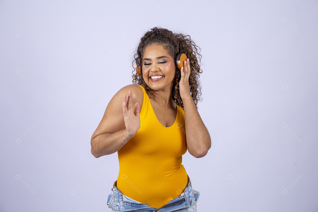Linda mulher com maiô amarelo com fone de ouvido em fundo branco