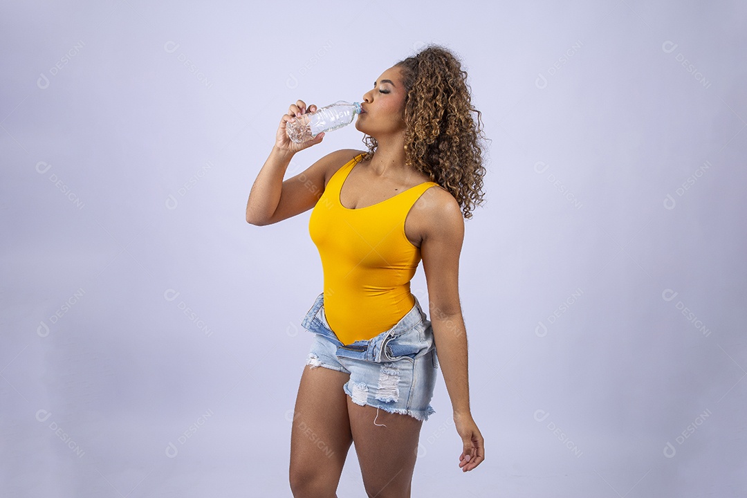 Linda mulher de maiô amarelo segurando garrafa de água