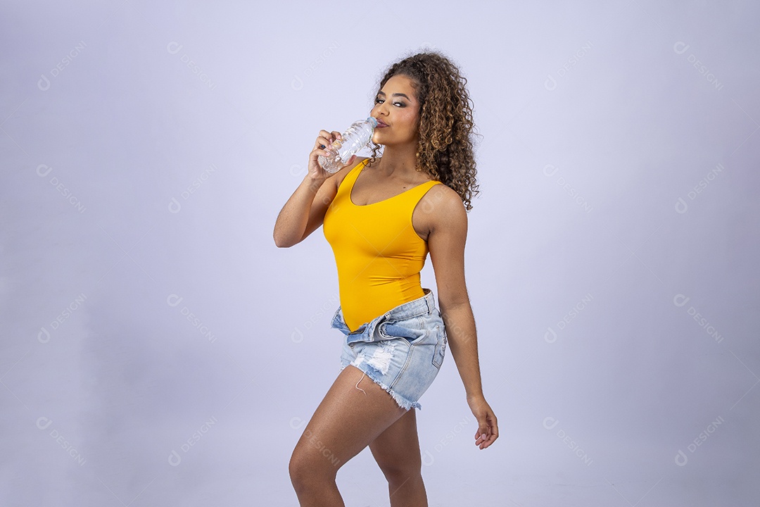 Linda mulher de maiô amarelo segurando garrafa de água