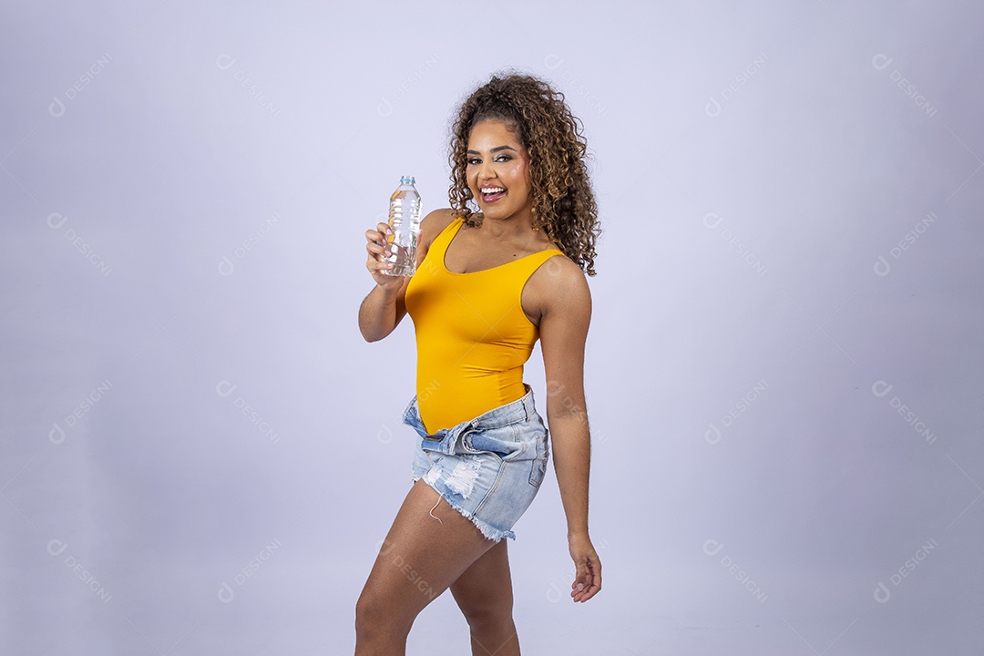 Linda mulher com maiô amarelo segurando garrafa de água