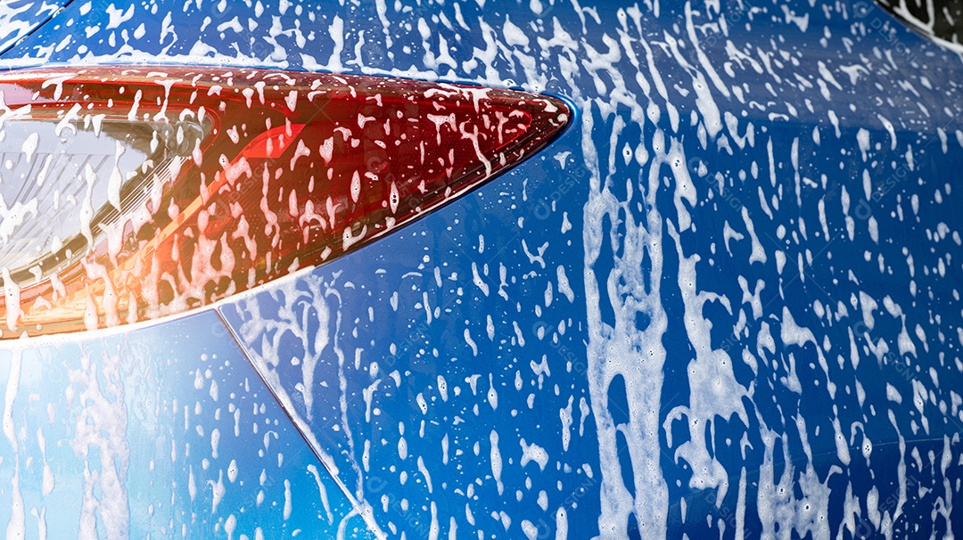 Lavagem de carros azul com espuma de sabão branco e serviço profissional de cuidados automotivos