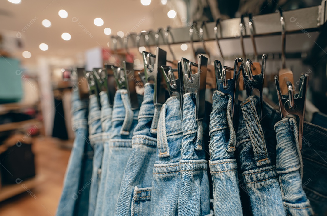 Calças jeans em loja de roupas. Jeans em cabide pendurado em cabide em loja de roupas