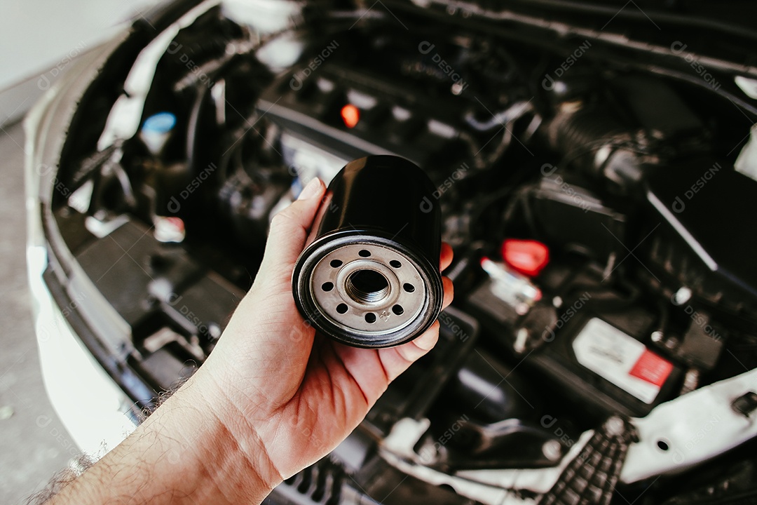 Mecânico de automóveis trocando filtro de óleo