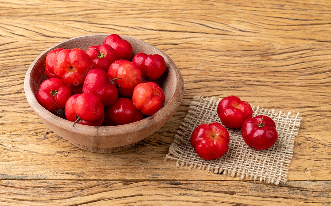 Acerolas ou cerejas de Barbados em uma tigela sobre a mesa de madeira.