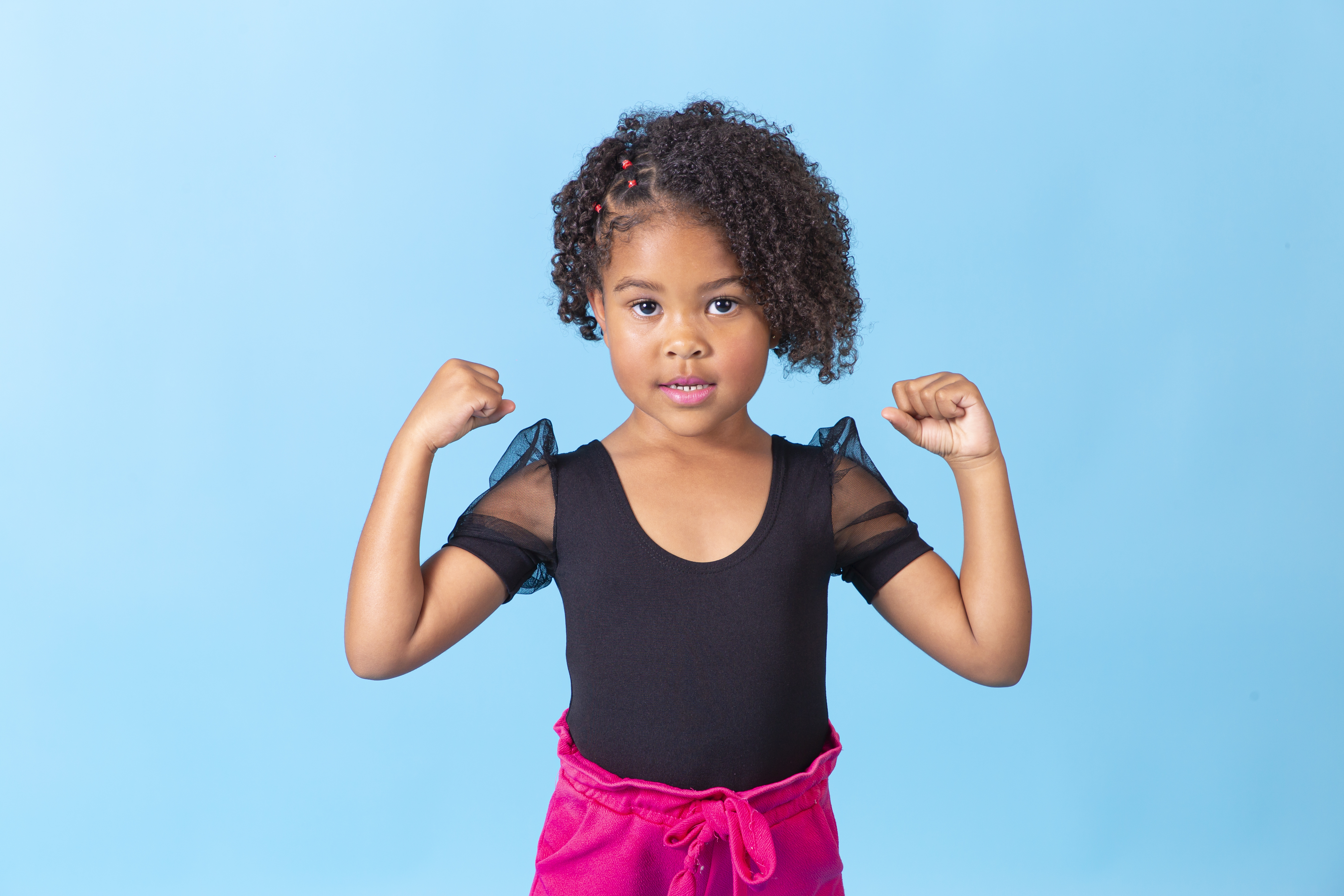 Linda garotinha segurando celular com tela preta em fundo azul