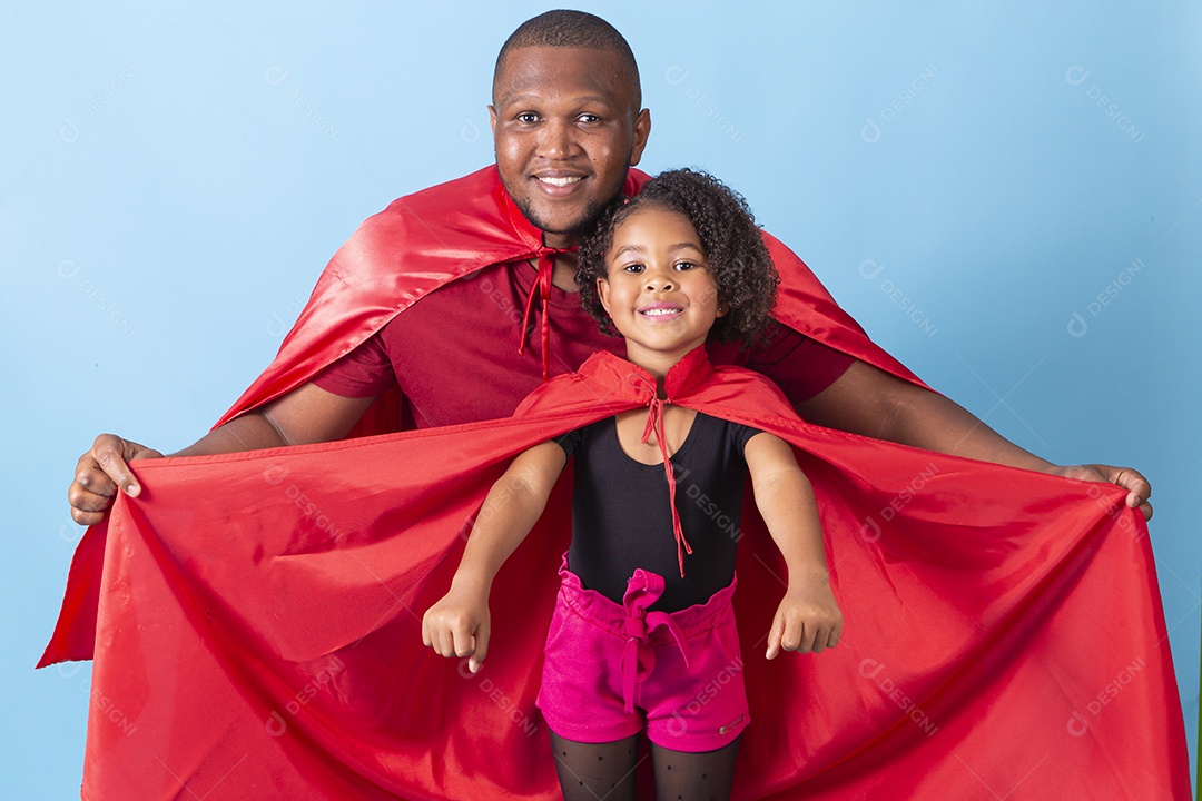 Pai e filha juntos com capa de super herói em fundo azul