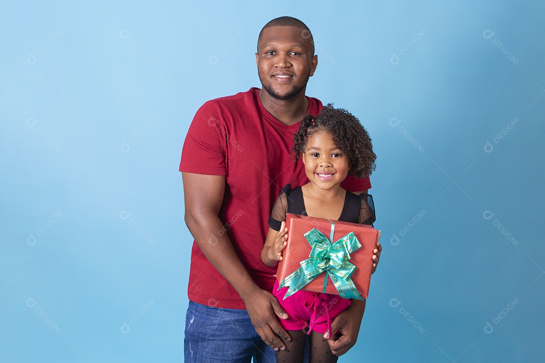 Pai e filha juntos com capa segurando presente em fundo azul