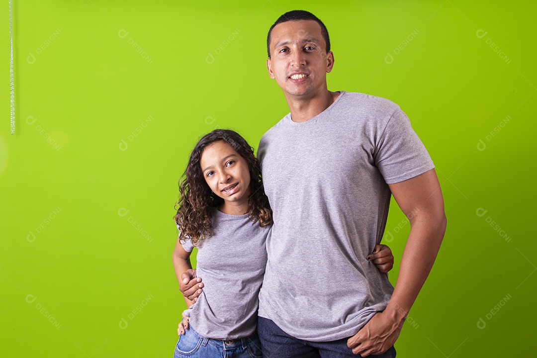 Pai e filha juntos combinando em fundo verde